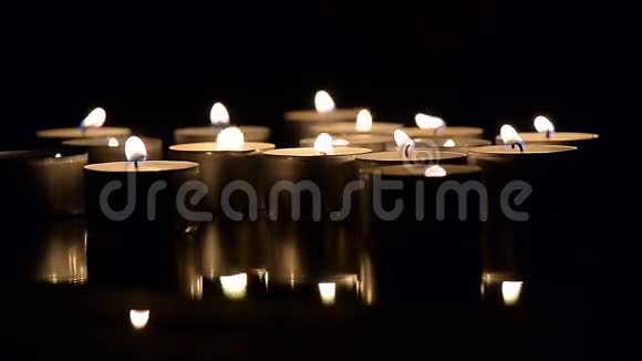 很多蜡烛在黑暗中燃烧在电影结束的时候视频的预览图