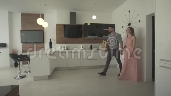 快乐的年轻夫妇在室内厨房里寻找现代时尚设计在4k镜头下移动新公寓视频的预览图