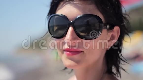 热带海滩上戴太阳镜的美丽年轻女子特写肖像视频的预览图