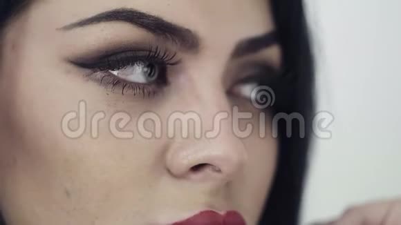 漂亮的女人的脸嘴唇大可爱的蓝色眼睛和长长的黑发视频的预览图