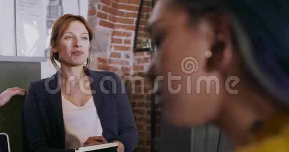同事和客户用笔记本电脑和平板电脑交谈策略有非正式商业团队的多族裔群体视频的预览图