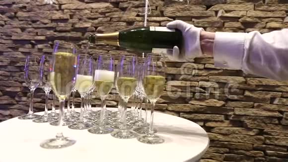 服务员将香槟倒入玻璃杯中香槟酒杯放在自助餐桌上室内特写视频的预览图