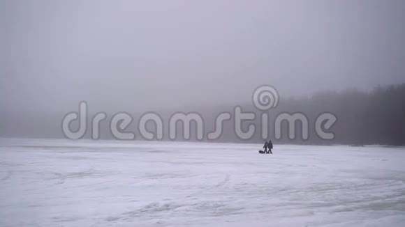 无法辨认的人在冰冻的湖面上行走视频的预览图