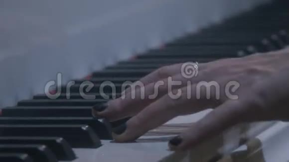 带戒指的女性手臂黑色指甲油弹钢琴的手链视频的预览图