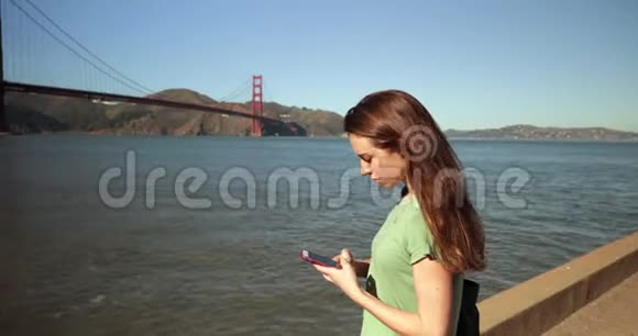 金门大桥使用智能手机的女人视频的预览图