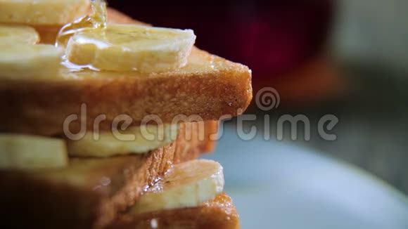 新鲜自制的脆土司蓝色盘子里有蜂蜜和香蕉美味的早餐视频的预览图
