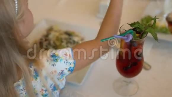 小女孩在咖啡馆里吃沙拉和喝浆果饮料视频的预览图