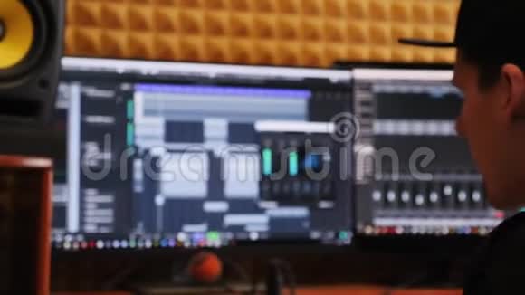 家庭录音室的音乐录制过程音响工程师用键盘和显示器混合和掌握音乐视频的预览图