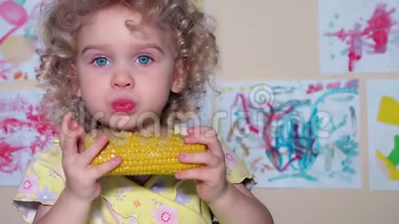 可爱的小女孩在玉米棒上吃煮玉米视频的预览图
