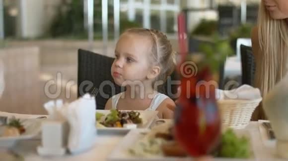 妈妈在餐馆帮小女儿吃希腊色拉视频的预览图