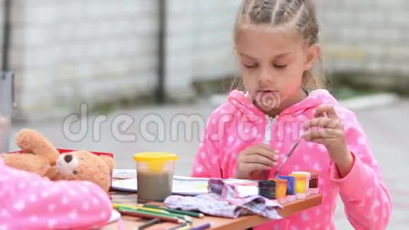 七岁的女孩在一张专辑中选择合适的彩色墨水画和另一个女孩坐在桌子旁视频的预览图