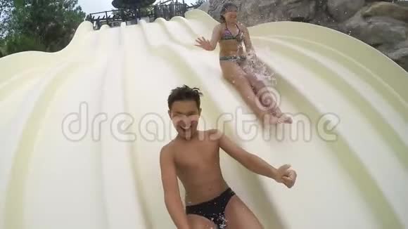 男孩和女孩骑下来溅到水里视频的预览图