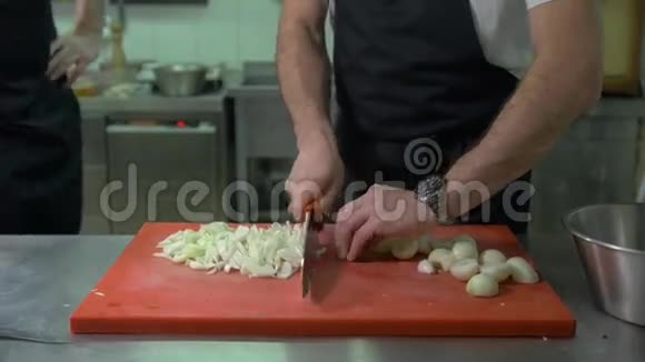 厨师在餐厅厨房用刀切开一个红洋葱视频的预览图