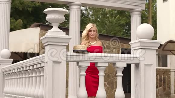 豪宅阳台上穿着红色连衣裙的优雅女孩视频的预览图