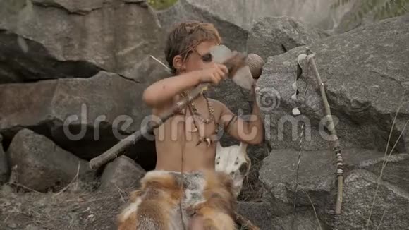 洞穴人在营地里制造原始的石制武器视频的预览图