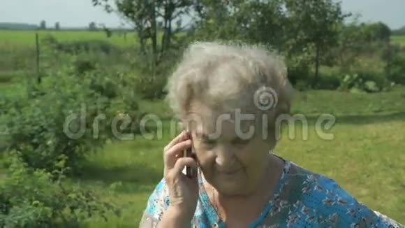 80岁的老年妇女在户外交流手机视频的预览图