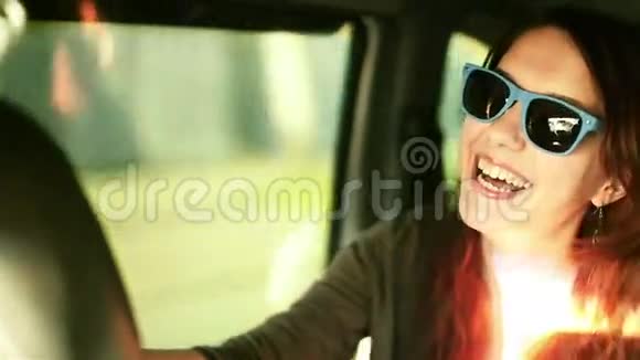 嘲笑戴太阳镜的女人在车里享受欢乐视频的预览图