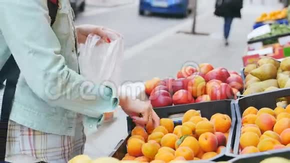在街头市场上检查水果的女人视频的预览图