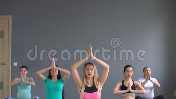 孕妇坐在膝盖上做呼吸练习女孩练习瑜伽视频的预览图