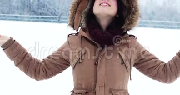穿着皮夹克享受降雪的微笑女人视频的预览图