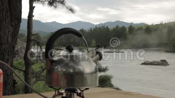 水壶在河底的煤气灶上沸腾视频的预览图