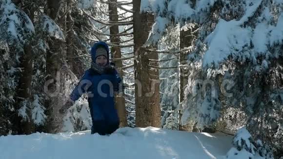 穿着蓝色运动服的孩子从雪山上滚下了头视频的预览图