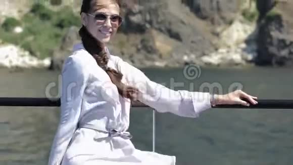 戴着墨镜的辫子微笑的女孩坐在船上视频的预览图