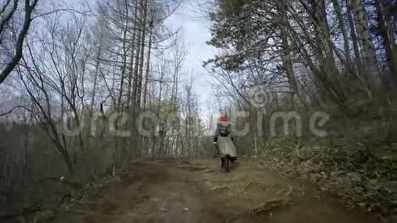 年轻漂亮的女人戴着红帽子在森林里游荡视频的预览图