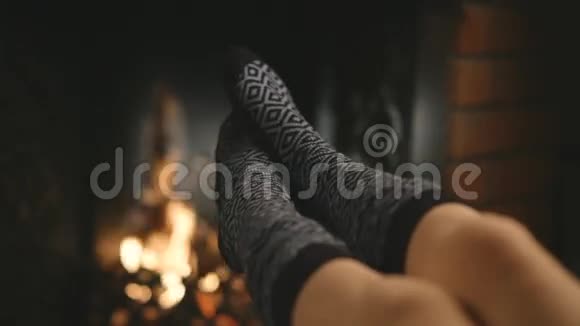 女孩在壁炉旁温暖双脚视频的预览图