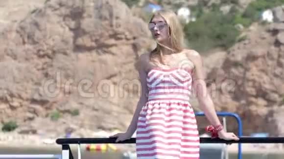 金发碧眼的穿着连衣裙戴着墨镜在海上乘船旅行视频的预览图