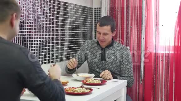 两个年轻人一起在厨房吃早餐烹饪食物和家庭概念午餐两个朋友男人在室内视频的预览图