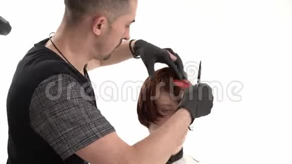 理发师拿着梳子和剪刀为一个生姜客户理发视频的预览图