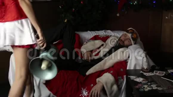 醉醺醺的圣诞老人躺在沙发上身穿狂欢节服装的女护士拿着扩音器试图叫醒他视频的预览图