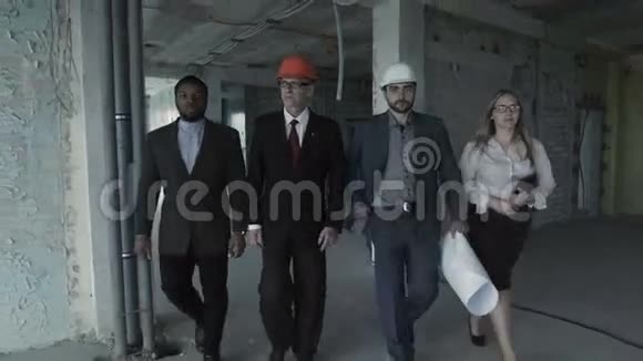 一队穿西装的建筑工人戴着安全帽移动直视镜头黑人老工程师视频的预览图