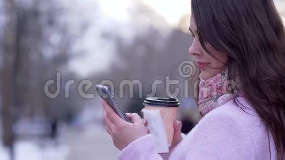 智能手机和塑料杯中的茶在露天为女性特写视频的预览图