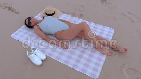 女人睡在海边的毛巾上视频的预览图