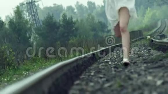 穿着白色裙子在铁轨上奔跑的女孩视频的预览图