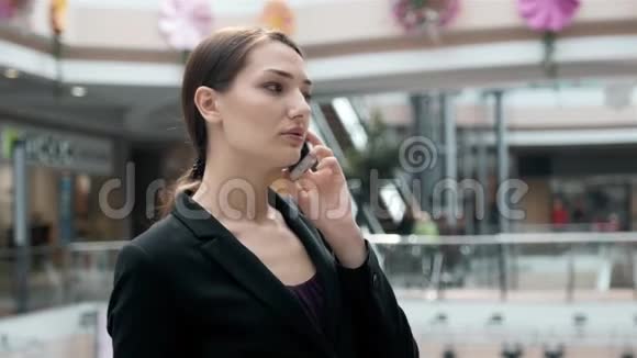 商场里的商人在打电话购物中心有智能手机的漂亮女孩女商人视频的预览图