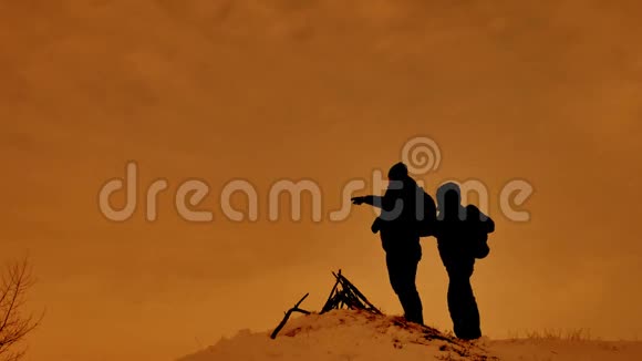 两位游客站在一座山上游客攀登一座阳光剪影山视频的预览图