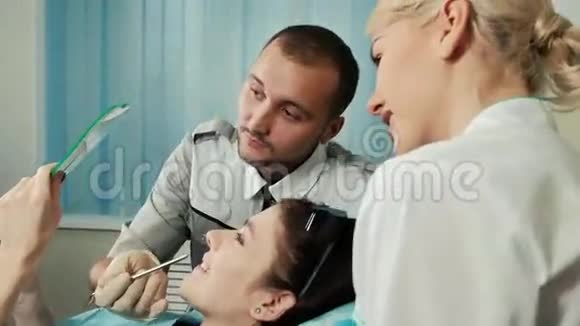 病人检查牙医在她的牙齿上工作坐在特殊的椅子上视频的预览图