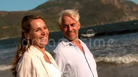 快乐的成熟夫妇一起在海滩上散步视频的预览图