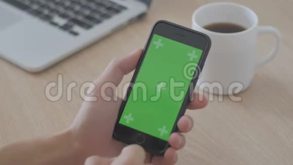 工作场所桌子上男性手触摸智能手机的特写绿色屏幕Chroma键视频的预览图