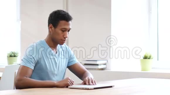 年轻黑人男子开放工作和关闭笔记本电脑视频的预览图