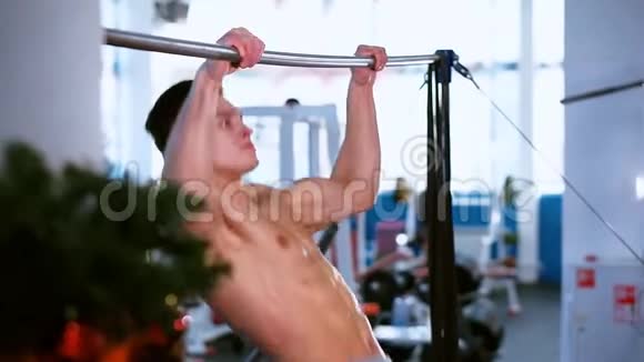 年轻的肌肉男在水平杆上锻炼视频的预览图