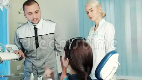 牙医和他的助手在牙科办公室仔细倾听病人的抱怨视频的预览图