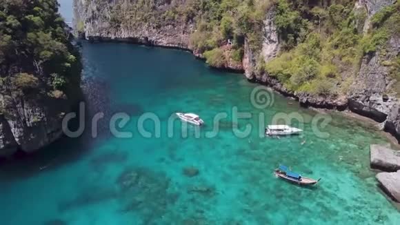 白色游艇在热带海洋附近的石灰岩岩石鸟瞰图视频的预览图