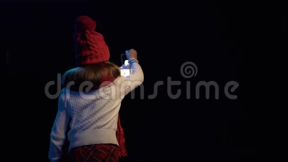 小女孩戴着针织冬帽围巾提着灯笼散步视频的预览图