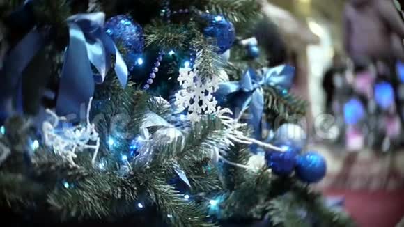 蓝色镜子和哑光球的滑块视图新年和圣诞树模糊的购物中心背景视频的预览图
