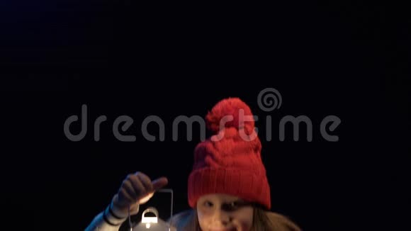小女孩戴着针织冬帽围巾提着灯笼散步视频的预览图