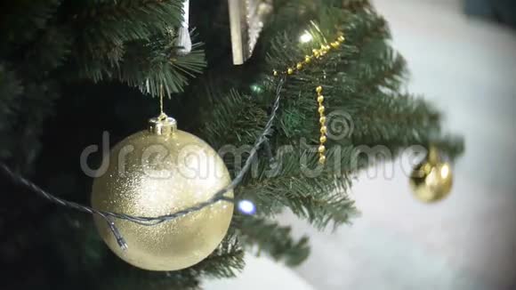 大的金色哑光球和灯新年和圣诞树模糊的购物中心背景视频的预览图